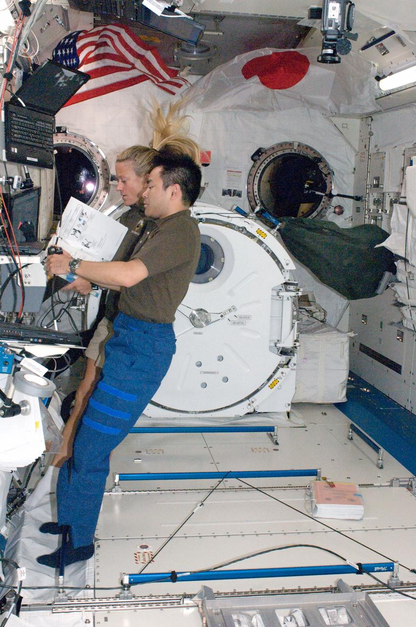 S124-E-007766 (9 June 2008) --- Japan Aerospace Exploration Agency astronaut Akihiko Hoshide and NASA astronaut Karen Nyberg, both STS-124 mission specialists, work the controls at the Japanese Remote Manipulator System in the Kibo Japanese Pressurized Module of the International Space Station while Space Shuttle Discovery is docked with the station.