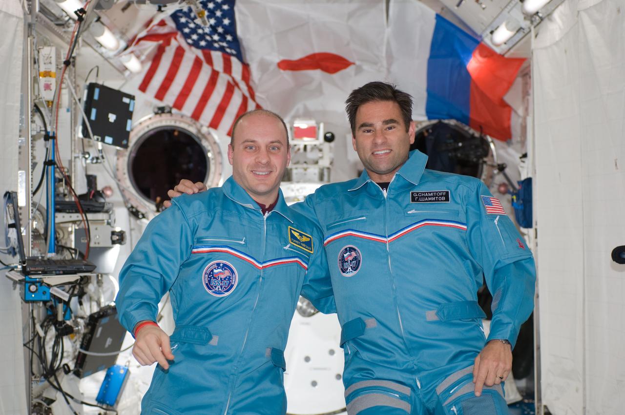 S124-E-007955 (9 June 2008) --- NASA astronauts Garrett Reisman, STS-124 mission specialist, and Greg Chamitoff, Expedition 17 flight engineer, pose for a portrait following a joint news conference with the STS-124 crewmembers from the Kibo Japanese Pressurized Module of the International Space Station while Space Shuttle Discovery is docked with the station. Reisman, who joined the station's crew in March, is being replaced by Chamitoff, who arrived at the station with the STS-124 crew.