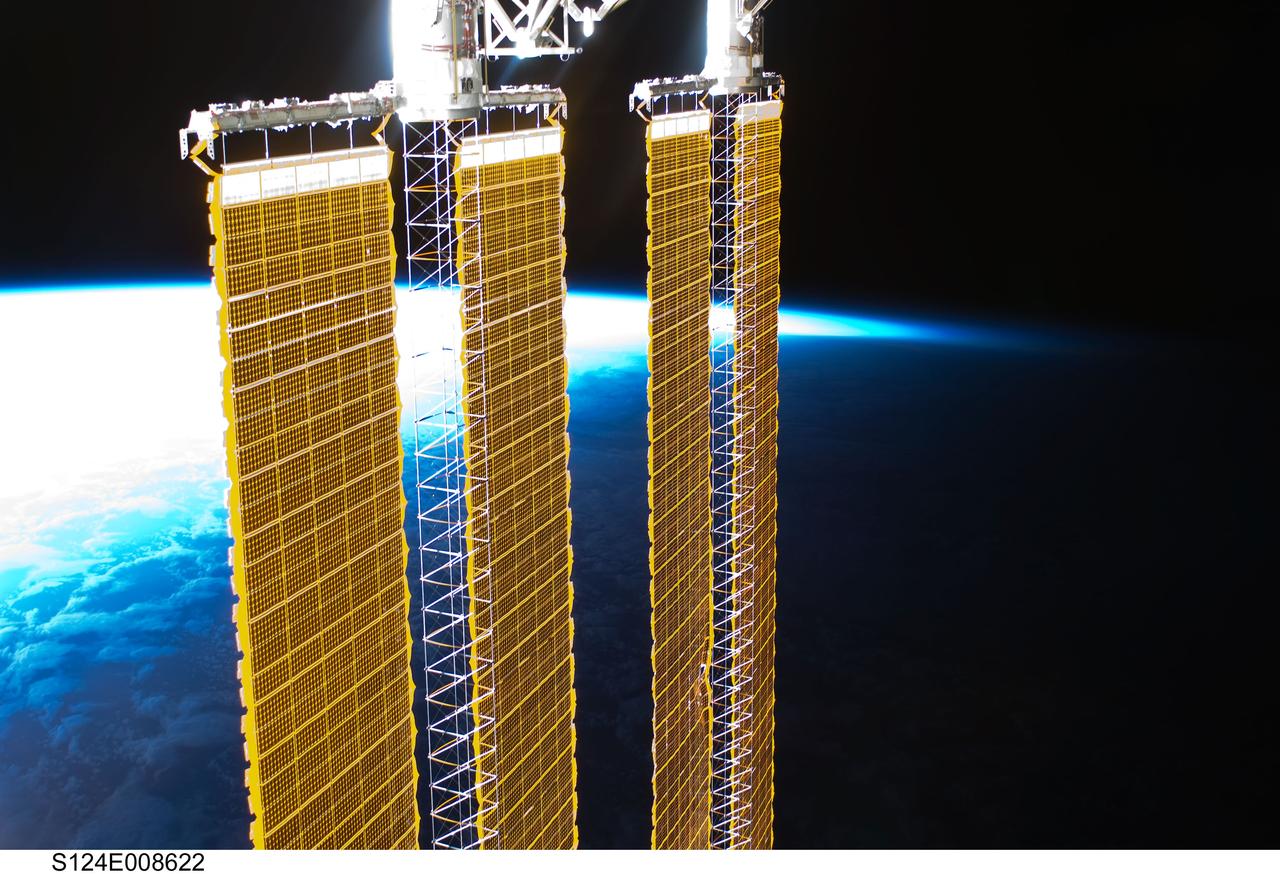 S124-E-008622 (10 June 2008) --- A partial view of International Space Station solar panels and Earth's horizon are photographed by a STS-124 crewmember on the International Space Station while Space Shuttle Discovery is docked with the station.