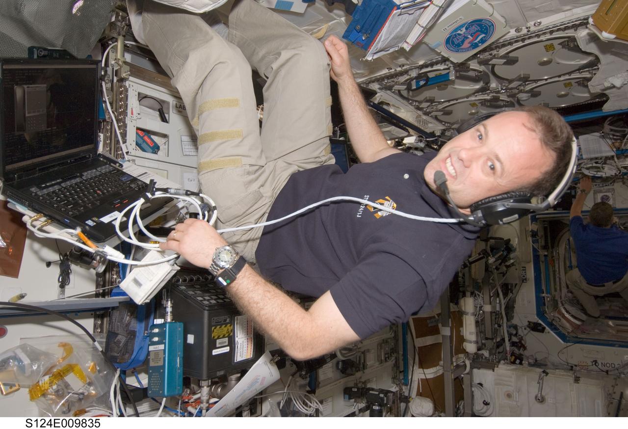 S124-E-009835 (10 June 2008) --- Astronaut Ron Garan, STS-124 mission specialist, takes a moment for a photo as he uses a communication system in the Destiny laboratory of the International Space Station while Space Shuttle Discovery is docked with the station.