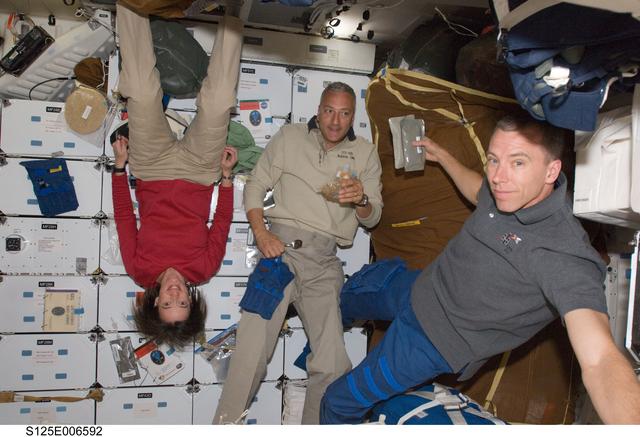 NASA image: Crew Members enjoy a meal on the Shuttle Atlantis Middeck