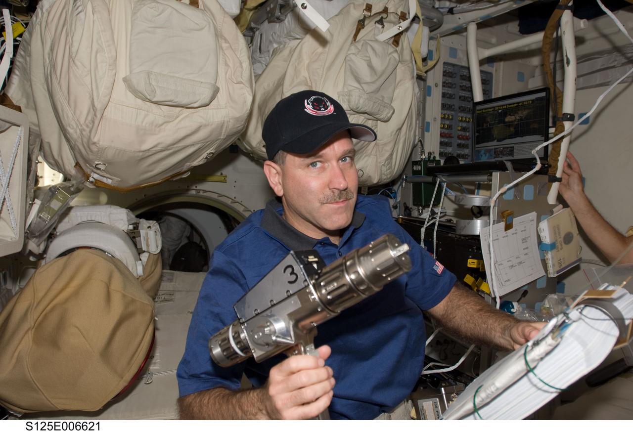 S125-E-006621 (13 May 2009) --- Astronaut John Grunsfeld, STS-125 mission specialist, works with a power tool on the middeck of Space Shuttle Atlantis as he prepares for upcoming spacewalks to repair the Hubble Space Telescope.