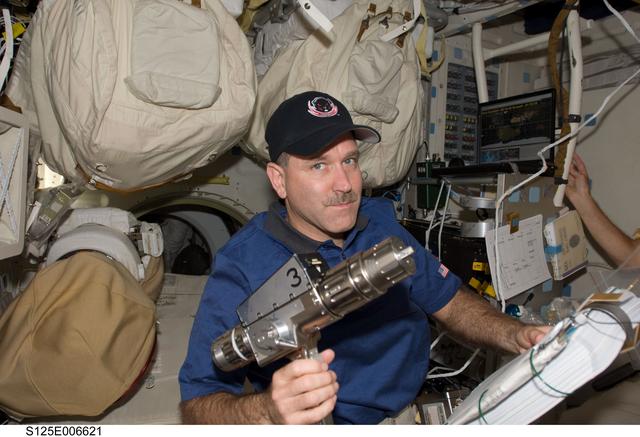 Grunsfeld poses for a photo on the Shuttle Atlantis Middeck