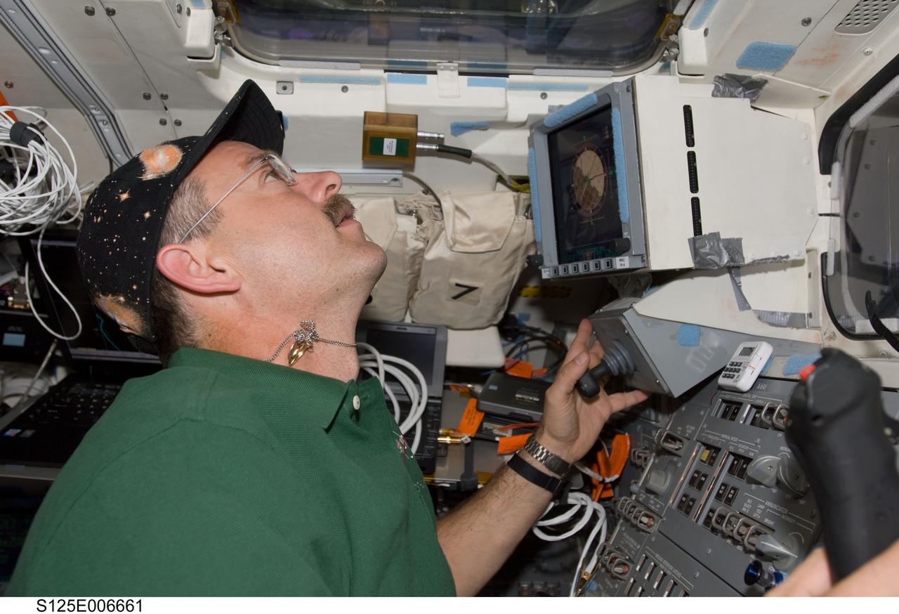 S125-E-006661 (13 May 2009) --- Astronaut Scott Altman, STS-125 commander, works the controls of the Space Shuttle Atlantis? remote manipulator system (RMS) robotic arm on the aft flight deck during the flight day three activities.