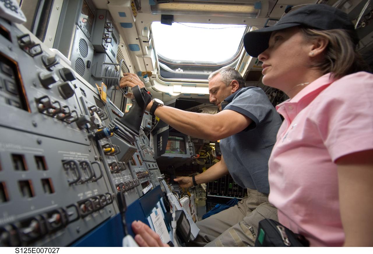 S125-E-007027 (13 May 2009) --- Astronauts Megan McArthur and Mike Massimino, both STS-125 mission specialists, work controls on the aft flight deck of Space Shuttle Atlantis during the flight day three activities.
