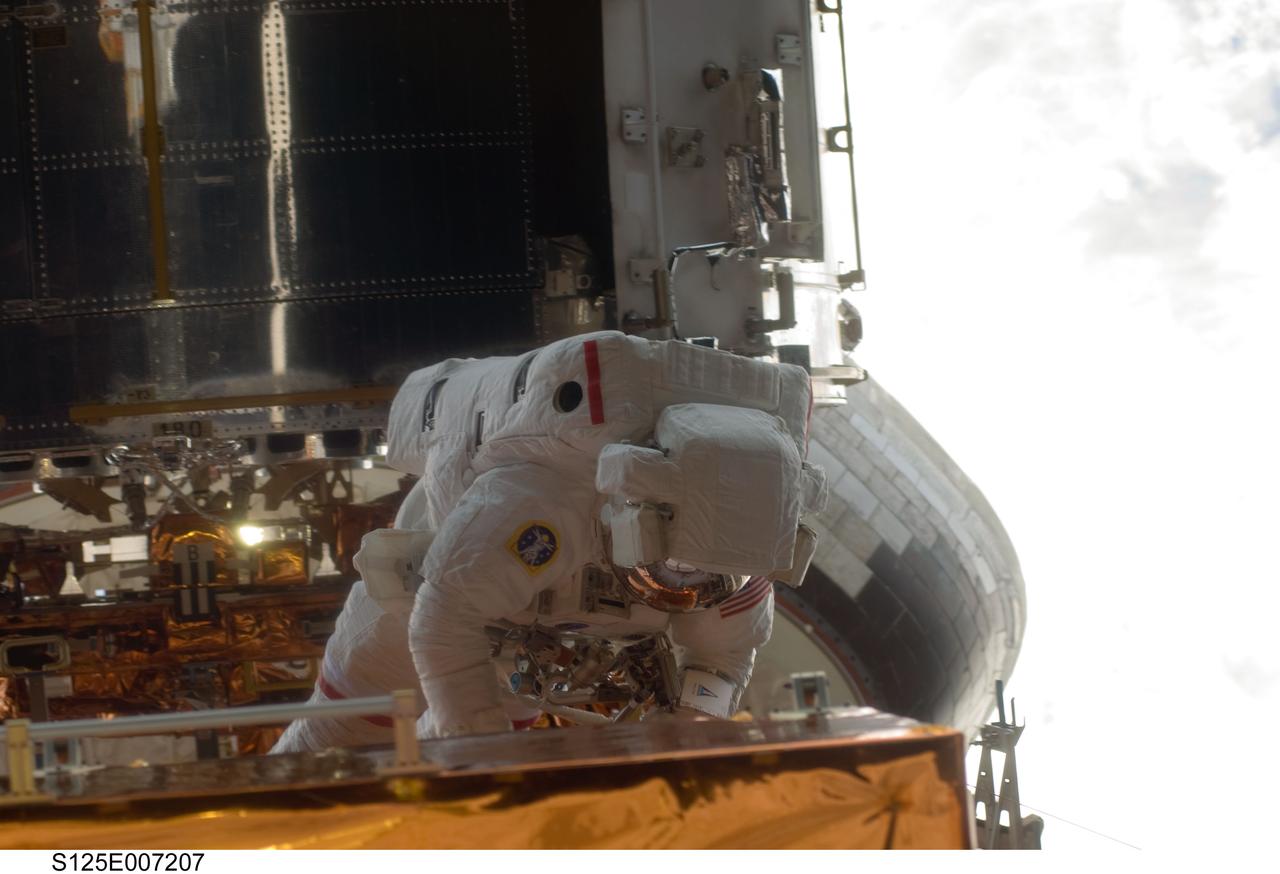 S125-E-007207 (14 May 2009) --- Astronaut John Grunsfeld, STS-125 mission specialist, participates in the first of his crew's five scheduled spacewalks in five consecutive days to perform the final hands-on servicing of the Hubble Space Telescope. Grunsfeld and his crewmate, astronaut Andrew Feustel, are slated for three of the five sessions.