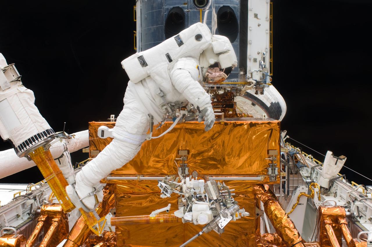 S125-E-007240 (14 May 2009) --- Astronaut Andrew Feustel, STS-125 mission specialist, appears to be selecting his next tool to use while participating in the first of his crew's five scheduled sessions of extravehicular activity to perform final hands-on servicing of the Hubble Space Telescope. Feustel and veteran astronaut John Grunsfeld (out of frame) are scheduled to participate in a total of three of those spacewalks.