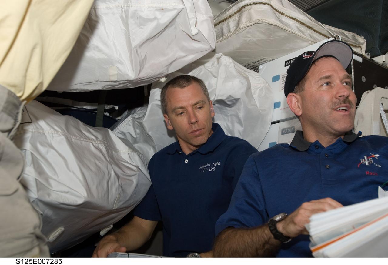 S125-E-007285 (13 May 2009) --- Astronaut Andrew Feustel (left) and John Grunsfeld, both STS-125 mission specialists, are pictured on the middeck of Space Shuttle Atlantis during flight day three activities.