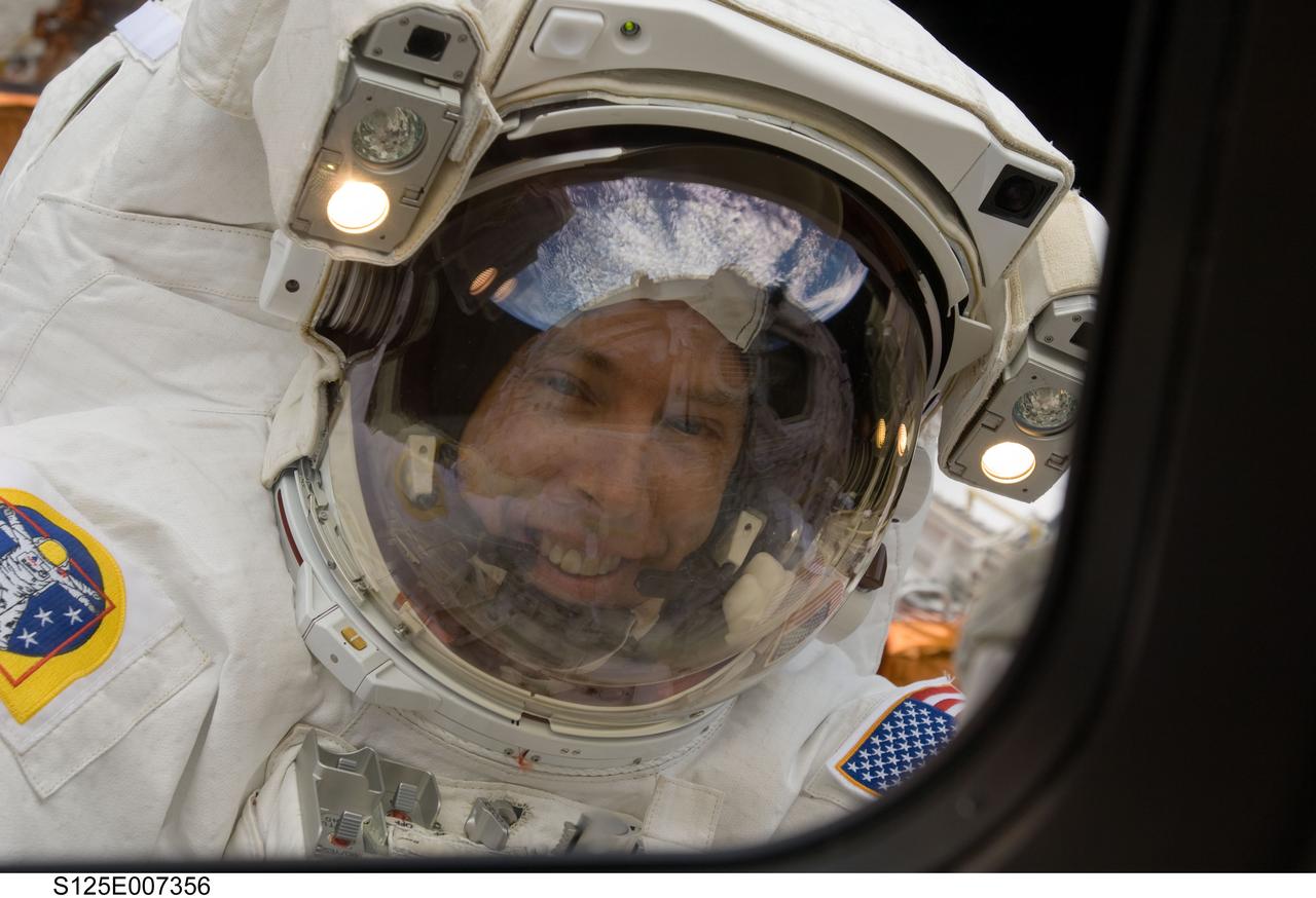 S125-E-007356 (14 May 2009) --- Astronaut Andrew Feustel, STS-125 mission specialist, is photographed from an aft flight deck window on the Space Shuttle Atlantis during the mission's first session of extravehicular activity (EVA) as work continues to refurbish and upgrade the Hubble Space Telescope.