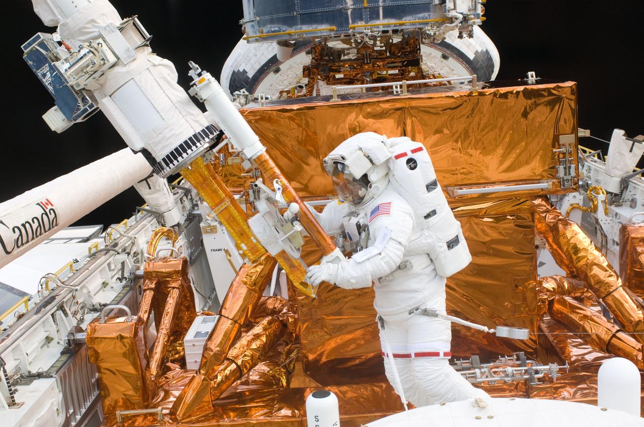 S125-E-007532 (15 May 2009) --- Astronaut Mike Massimino in Atlantis' cargo bay works with the Hubble Space Telescope.