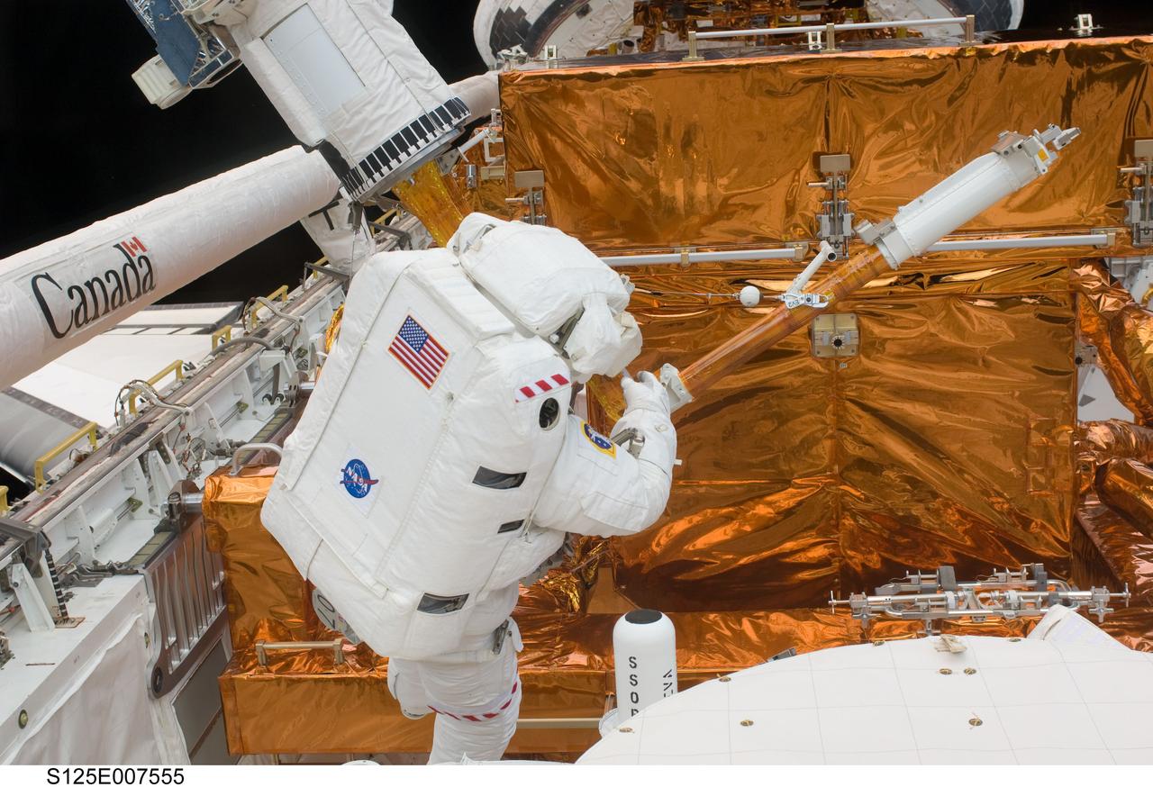 S125-E-007555 (15 May 2009) --- Astronaut Michael Good works with the Hubble Space Telescope in the cargo bay of the Earth-orbiting Space Shuttle Atlantis. Astronauts Good and Mike Massimino (out of frame) participated in the second session of STS-125 extravehicular activity -- as part of a five-day beehive-like agenda of spacewalking and work on the giant orbital observatory.