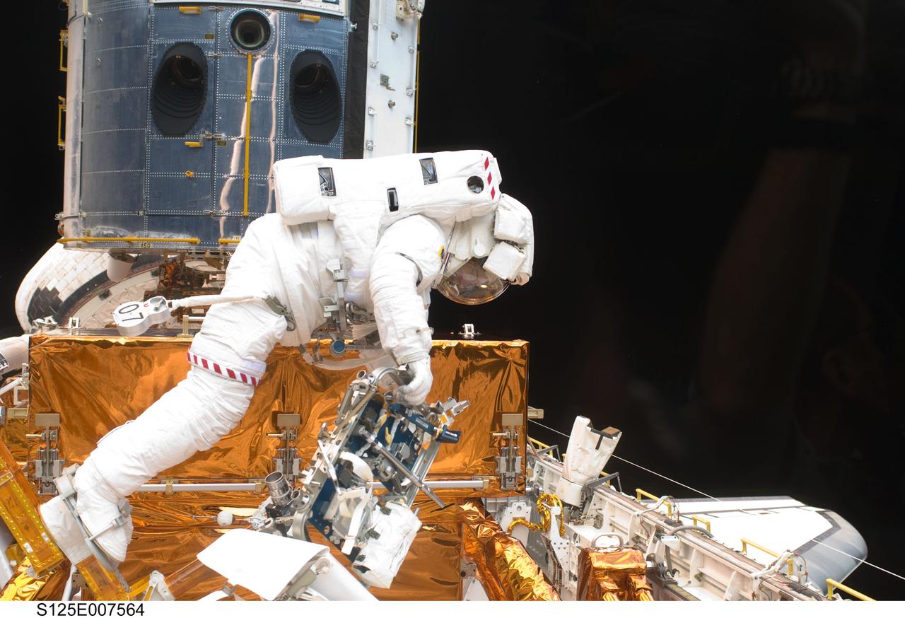 S125-E-007564 (15 May 2009) --- Astronaut Michael Good works with the Hubble Space Telescope in the cargo bay of the Earth-orbiting Space Shuttle Atlantis. Astronauts Good and Mike Massimino (out of frame) participated in the second session of STS-125 extravehicular activity -- as part of a five-day beehive-like agenda of spacewalking and work on the giant orbital observatory.