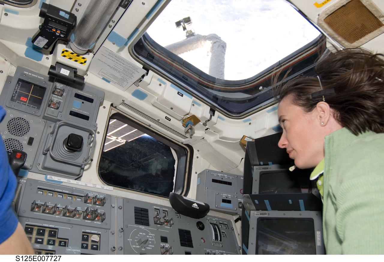 S125-E-007727 (15 May 2009) --- Astronaut Megan McArthur, STS-125 mission specialist, focuses on chores in support of the Atlantis' second session of extravehicular activity from the aft side of the crew cabin, where controls for the remote manipulator system arm, among other important elements, are located. Equipped with TV monitors and direct vision capabilities, via this vantage point she also can maintain visual contact with the two space walkers as they perform work on the Hubble Space Telescope, locked down in the shuttle's cargo bay.