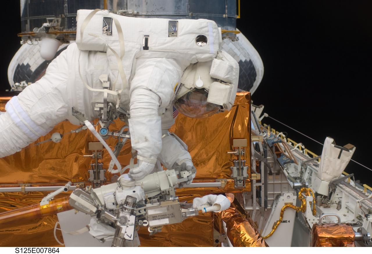 S125-E-007864 (16 May 2009) --- With the Hubble Space Telescope in the background, astronaut Andrew Feustel, STS-125 mission specialist, is seen here working during the mission?s third extravehicular activity (EVA). Feustel and astronaut John Grunsfeld (out of frame), mission specialist, removed the Corrective Optics Space Telescope Axial Replacement and installed in its place the new Cosmic Origins Spectrograph. They also completed the Advanced Camera for Surveys electronic card replacement work, and completed part 2 of the ACS repair, installing a new electronics box and cable.