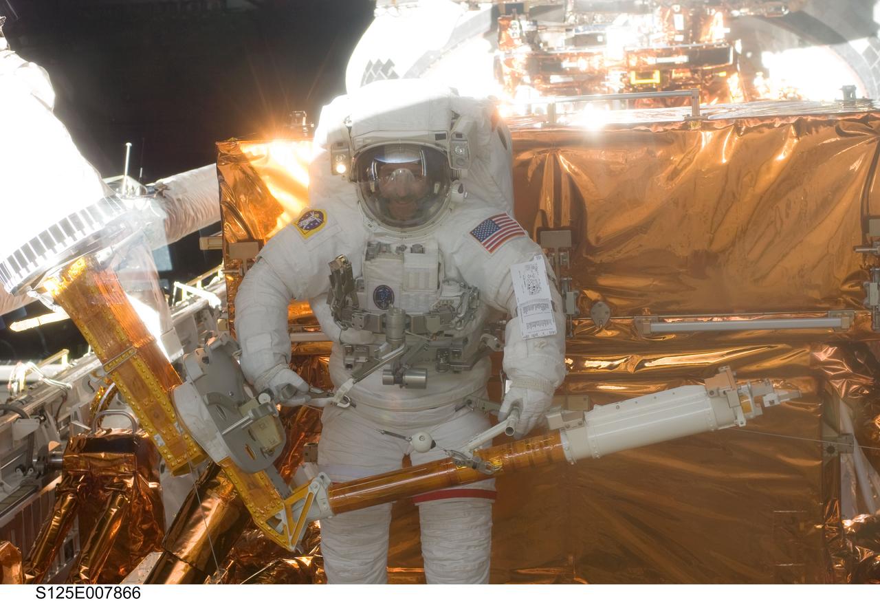 S125-E-007866 (16 May 2009) --- Astronaut John Grunsfeld, STS-125 mission specialist, participates in the mission?s third session of extravehicular activity (EVA) as work continues to refurbish and upgrade the Hubble Space Telescope. During the six-hour, 36-minute spacewalk, Grunsfeld and astronaut Andrew Feustel (out of frame), mission specialist, removed the Corrective Optics Space Telescope Axial Replacement and installed in its place the new Cosmic Origins Spectrograph. They also completed the Advanced Camera for Surveys electronic card replacement work, and completed part 2 of the ACS repair, installing a new electronics box and cable.