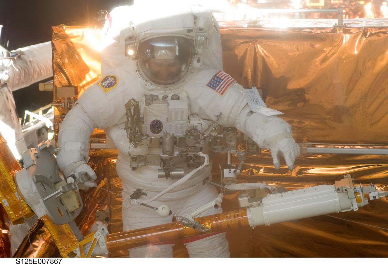 S125-E-007867 (16 May 2009) --- Astronaut John Grunsfeld, STS-125 mission specialist, participates in the mission?s third session of extravehicular activity (EVA) as work continues to refurbish and upgrade the Hubble Space Telescope. During the six-hour, 36-minute spacewalk, Grunsfeld and astronaut Andrew Feustel (out of frame), mission specialist, removed the Corrective Optics Space Telescope Axial Replacement and installed in its place the new Cosmic Origins Spectrograph. They also completed the Advanced Camera for Surveys electronic card replacement work, and completed part 2 of the ACS repair, installing a new electronics box and cable.