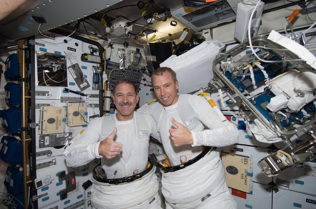S125-E-008027 (16 May 2009) --- Astronauts John Grunsfeld (left) and Andrew Feustel, both STS-125 mission specialists, give a `thumbs-up? sign on the middeck of Space Shuttle Atlantis following the mission?s third session of extravehicular activity (EVA).