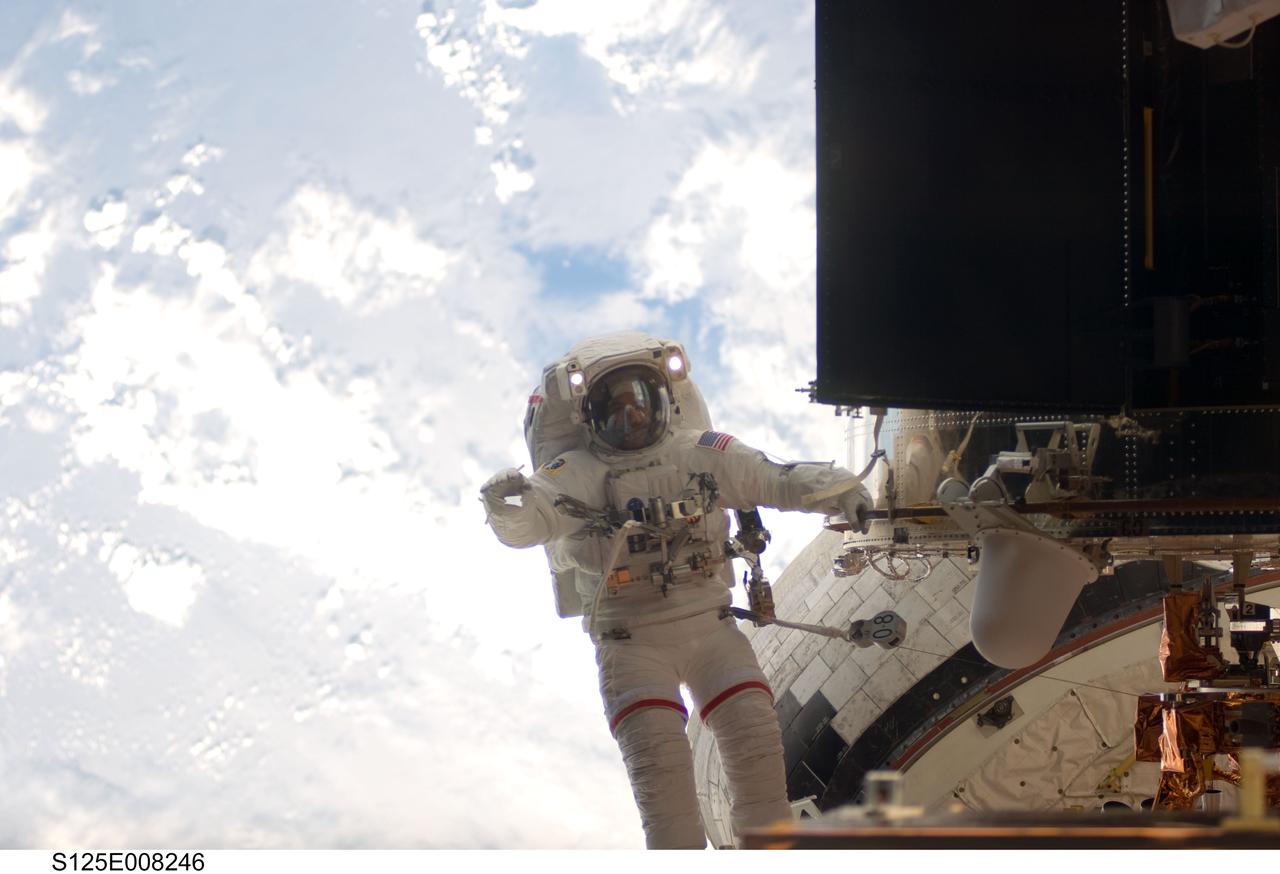 S125-E-008246 (16 May 2009) --- Astronaut John Grunsfeld, STS-125 mission specialist, participates in the mission?s third session of extravehicular activity (EVA) as work continues to refurbish and upgrade the Hubble Space Telescope. During the six-hour, 36-minute spacewalk, Grunsfeld and astronaut Andrew Feustel (out of frame), mission specialist, removed the Corrective Optics Space Telescope Axial Replacement and installed in its place the new Cosmic Origins Spectrograph. They also completed the Advanced Camera for Surveys electronic card replacement work, and completed part 2 of the ACS repair, installing a new electronics box and cable.