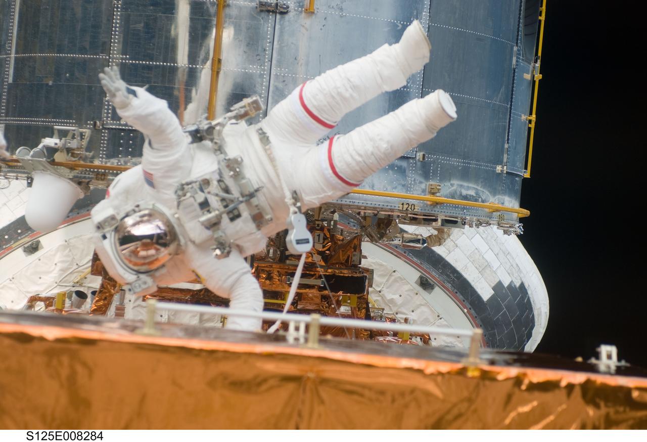 S125-E-008284 (16 May 2009) --- Astronaut John Grunsfeld, STS-125 mission specialist, participates in the mission?s third session of extravehicular activity (EVA) as work continues to refurbish and upgrade the Hubble Space Telescope. During the six-hour, 36-minute spacewalk, Grunsfeld and astronaut Andrew Feustel (out of frame), mission specialist, removed the Corrective Optics Space Telescope Axial Replacement and installed in its place the new Cosmic Origins Spectrograph. They also completed the Advanced Camera for Surveys electronic card replacement work, and completed part 2 of the ACS repair, installing a new electronics box and cable.