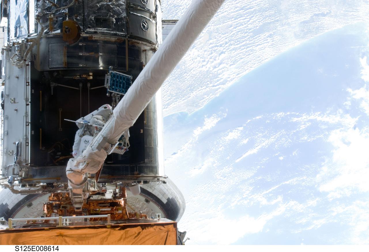 S125-E-008614 (17 May 2009) --- Astronaut Michael Good, STS-125 mission specialist, repositions himself on Atlantis' remote manipulator system as he continues work on the Hubble Space Telescope during the mission's fourth session of extravehicular activity.  Astronaut Mike Massimino, who shared two spacewalks with Good during the last week, is out of frame.