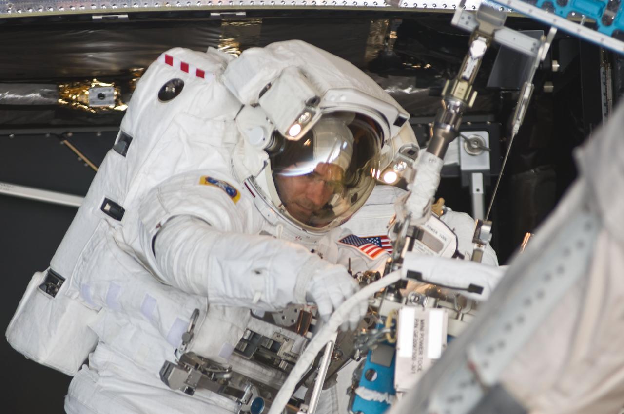 S125-E-008639 (17 May 2009) --- Astronaut Michael Good, STS-125 mission specialist, participates in the mission?s fourth session of extravehicular activity (EVA) as work continues to refurbish and upgrade the Hubble Space Telescope. During the eight-hour, two-minute spacewalk, Good and astronaut Mike Massimino (out of frame), mission specialist, continued repairs and improvements to the Space Telescope Imaging Spectrograph (STIS) that will extend the Hubble?s life into the next decade.