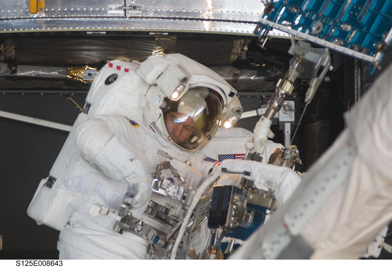 S125-E-008643 (17 May 2009) --- Astronaut Michael Good, STS-125 mission specialist, participates in the mission?s fourth session of extravehicular activity (EVA) as work continues to refurbish and upgrade the Hubble Space Telescope. During the eight-hour, two-minute spacewalk, Good and astronaut Mike Massimino (out of frame), mission specialist, continued repairs and improvements to the Space Telescope Imaging Spectrograph (STIS) that will extend the Hubble?s life into the next decade.