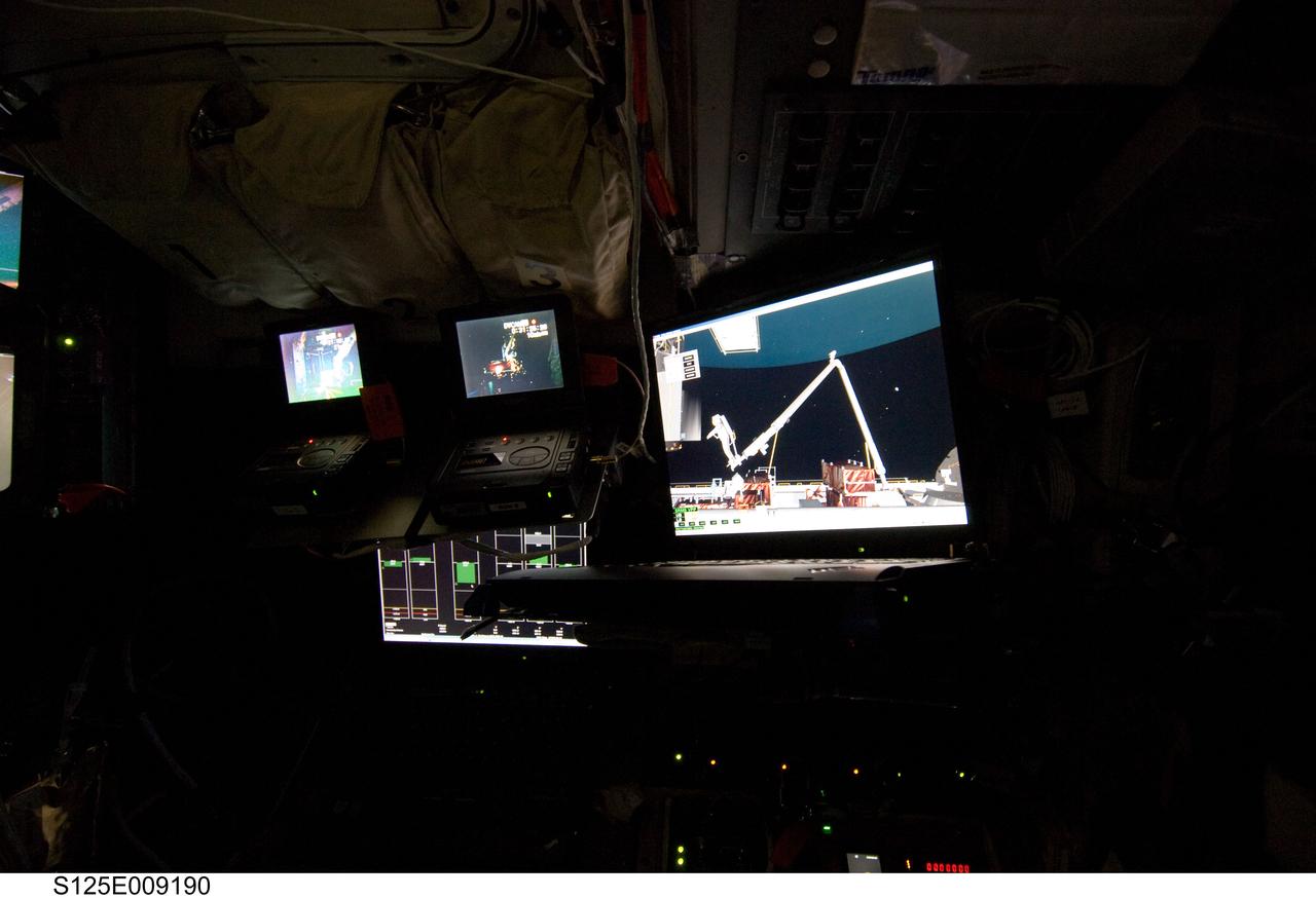 S125-E-009190 (17 May 2009) --- A computer monitor showing animation of an extravehicular activity (EVA) is visible in this image photographed by a STS-125 crewmember in a darkened flight deck on the Earth-orbiting Space Shuttle Atlantis.