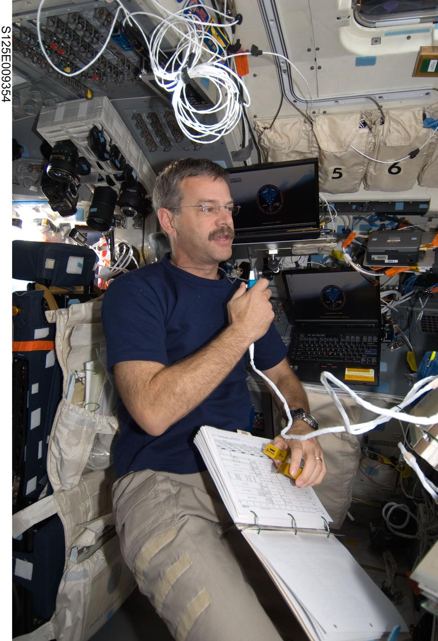 S125-E-009354 (17 May 2009) --- Astronaut Scott Altman, STS-125 commander, uses a communication system on the aft flight deck of the Earth-orbiting Space Shuttle Atlantis during flight day seven activities.
