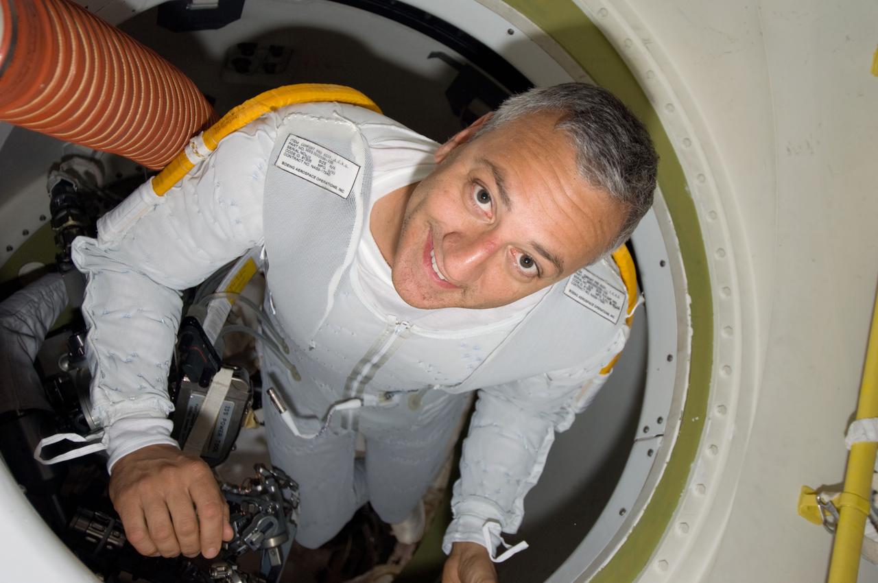 S125-E-009381 (17 May 2009) --- Astronaut Mike Massimino, STS-125 mission specialist, wearing the liquid cooling and ventilation garment that complements the Extravehicular Mobility Unit (EMU) spacesuit, is pictured in a hatch on the Earth-orbiting Space Shuttle Atlantis prior to the mission?s fourth session of extravehicular activity (EVA).