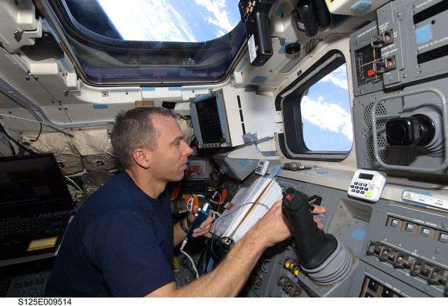 NASA image: STS-125 MS5 Andrew Feustel works on the Flight Deck during Flight Day 7