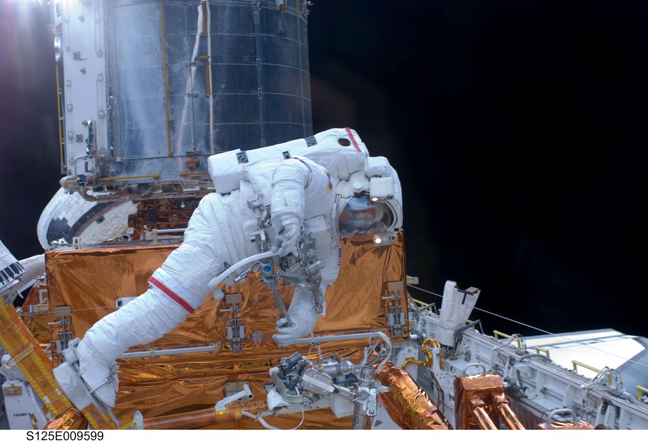 S125-E-009599 (18 May 2009) --- Astronaut John Grunsfeld, STS-125 mission specialist, participates in the mission?s fifth and final session of extravehicular activity (EVA) as work continues to refurbish and upgrade the Hubble Space Telescope. During the seven-hour and two-minute spacewalk, Grunsfeld and astronaut Andrew Feustel (out of frame), mission specialist, installed a battery group replacement, removed and replaced a Fine Guidance Sensor and three thermal blankets (NOBL) protecting Hubble?s electronics.