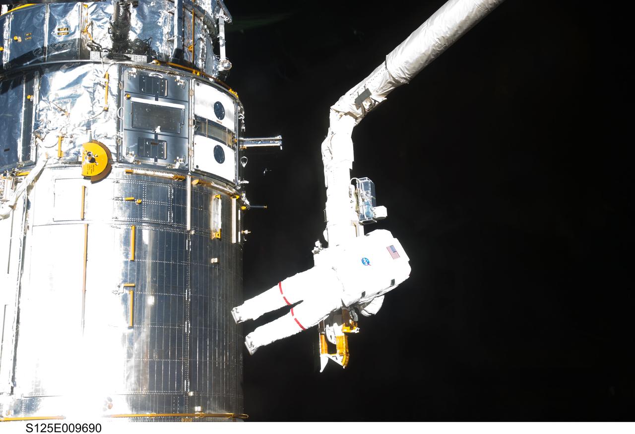 S125-E-009690 (18 May 2009) --- Astronaut John Grunsfeld, STS-125 mission specialist, participates in the mission?s fifth and final session of extravehicular activity (EVA) as work continues to refurbish and upgrade the Hubble Space Telescope. During the seven-hour and two-minute spacewalk, Grunsfeld and astronaut Andrew Feustel (out of frame), mission specialist, installed a battery group replacement, removed and replaced a Fine Guidance Sensor and three thermal blankets (NOBL) protecting Hubble?s electronics.