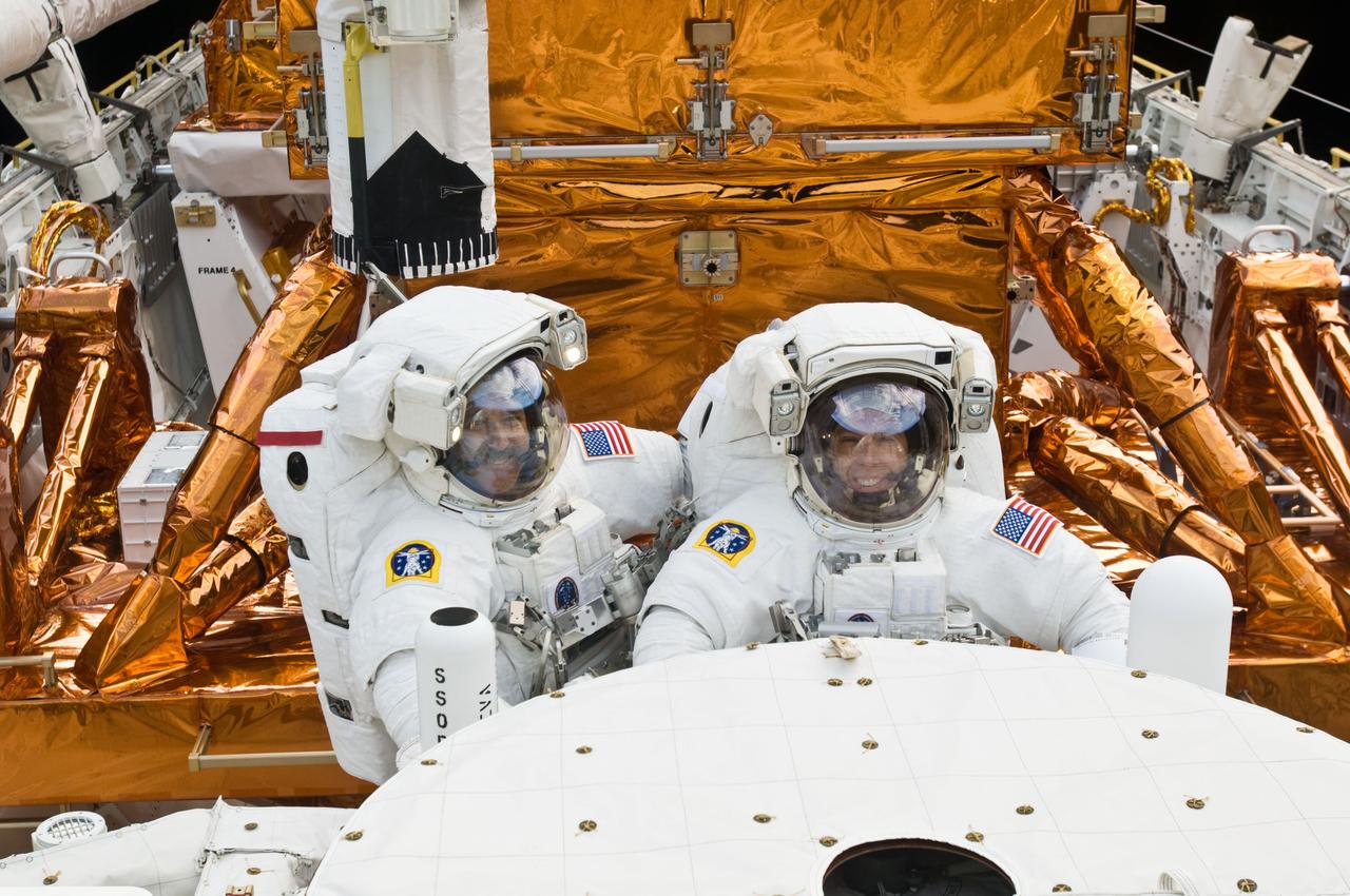 S125-E-009721 (18 May 2009) --- Astronauts John Grunsfeld (left) and Andrew Feustel, both STS-125 mission specialists, participate in the mission?s fifth and final session of extravehicular activity (EVA) as work continues to refurbish and upgrade the Hubble Space Telescope. During the seven-hour and two-minute spacewalk, Grunsfeld and Feustel installed a battery group replacement, removed and replaced a Fine Guidance Sensor and three thermal blankets (NOBL) protecting Hubble?s electronics.