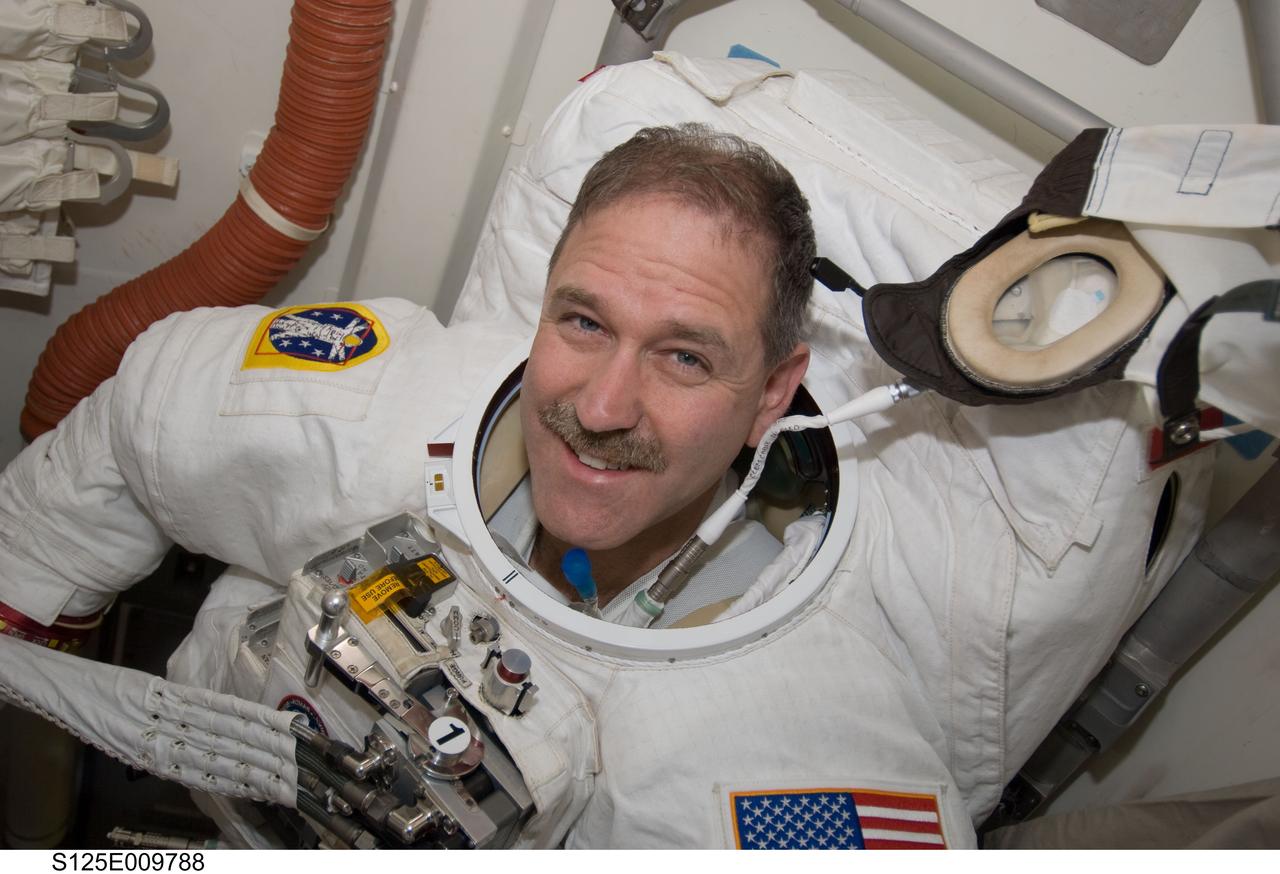 S125-E-009788 (18 May 2009) --- Astronaut John Grunsfeld, STS-125 mission specialist, attired in his Extravehicular Mobility Unit (EMU) spacesuit, is pictured in the Earth-orbiting Space Shuttle Atlantis? airlock as he prepares for the mission?s fifth and final session of extravehicular activity (EVA).