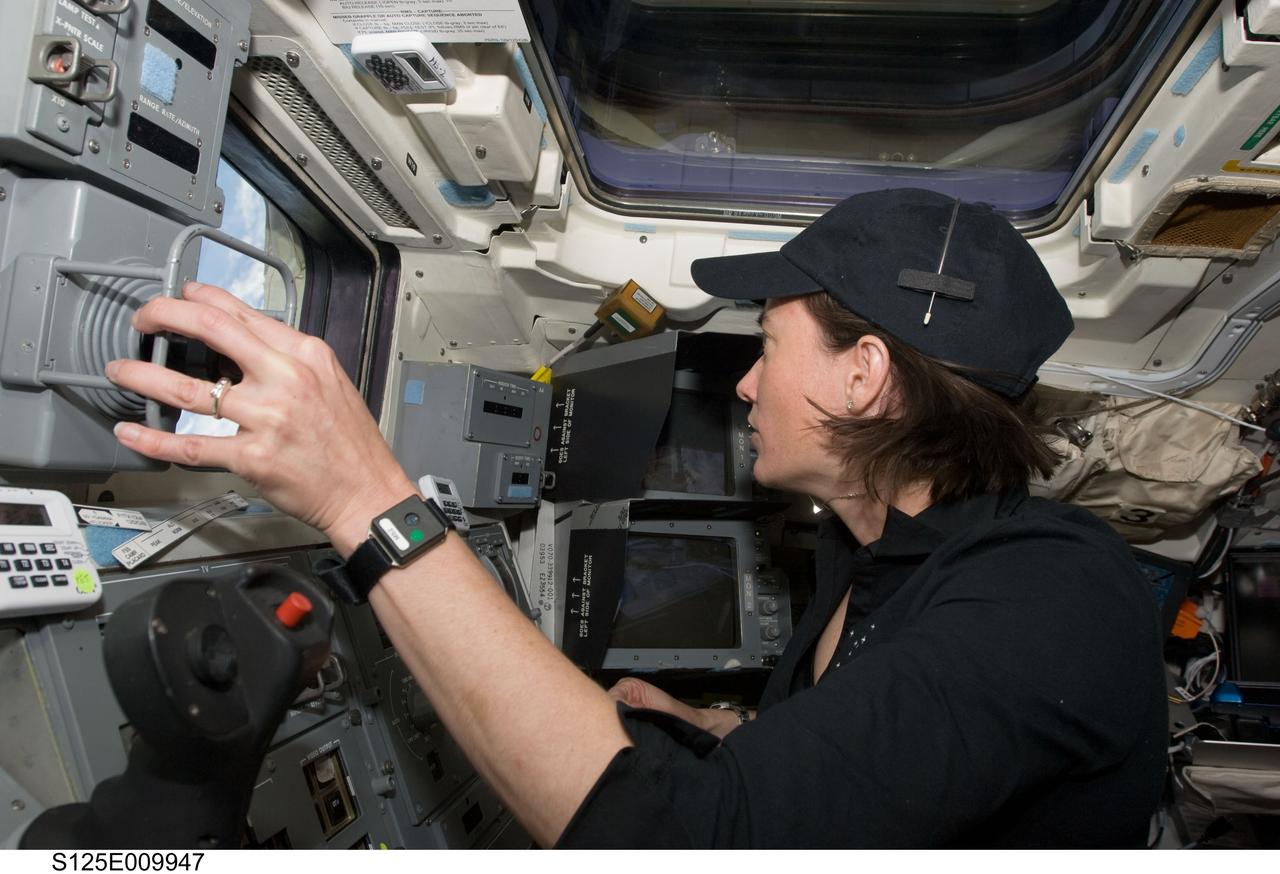 S125-E-009947 (18 May 2009) --- Astronaut Megan McArthur, STS-125 mission specialist, works the controls of the remote manipulator system (RMS) on the aft flight deck of the Earth-orbiting Space Shuttle Atlantis during flight day eight activities.