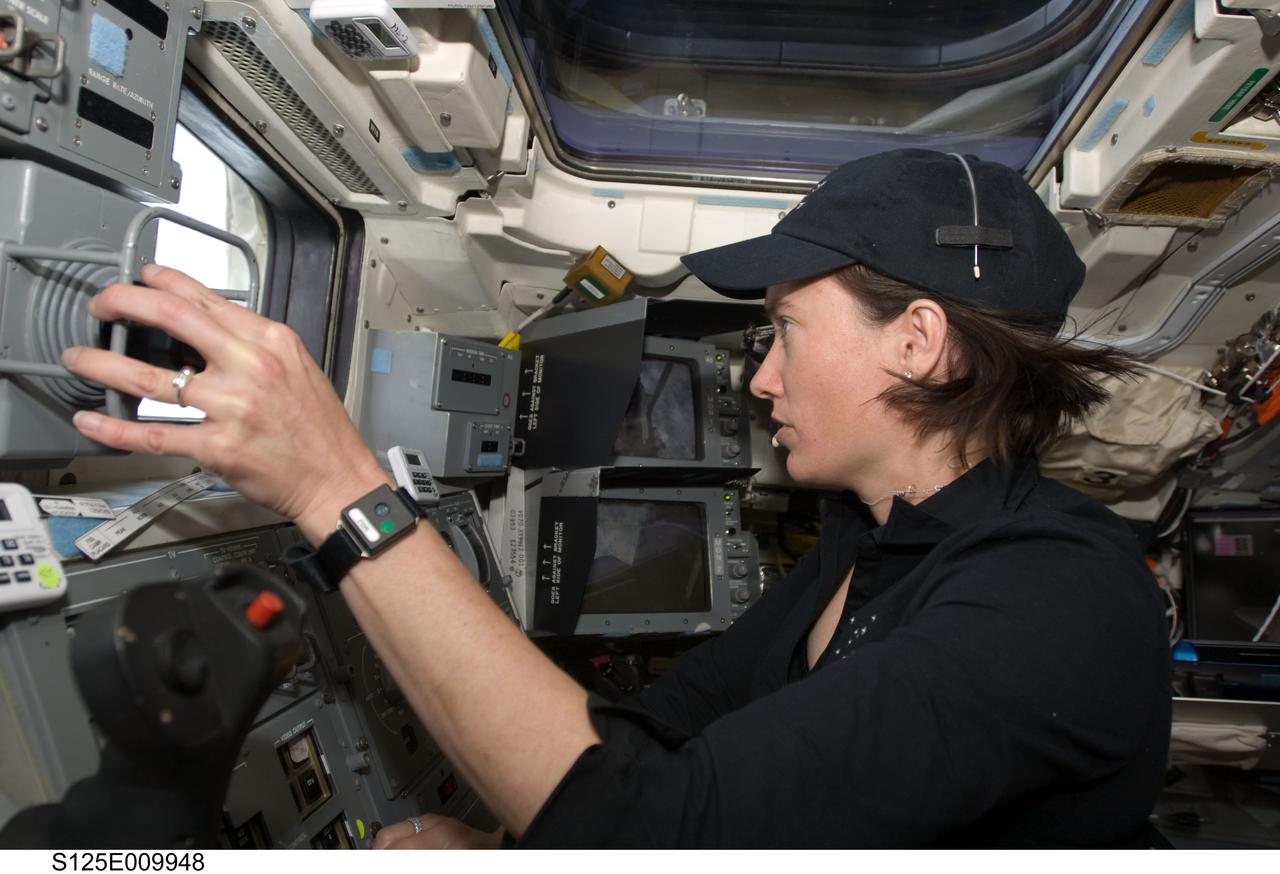 S125-E-009948 (18 May 2009) --- Astronaut Megan McArthur, STS-125 mission specialist, works the controls of the remote manipulator system (RMS) on the aft flight deck of the Earth-orbiting Space Shuttle Atlantis during flight day eight activities.