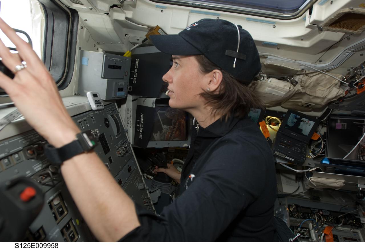 S125-E-009958 (18 May 2009) --- Astronaut Megan McArthur, STS-125 mission specialist, works the controls of the remote manipulator system (RMS) on the aft flight deck of the Earth-orbiting Space Shuttle Atlantis during flight day eight activities.