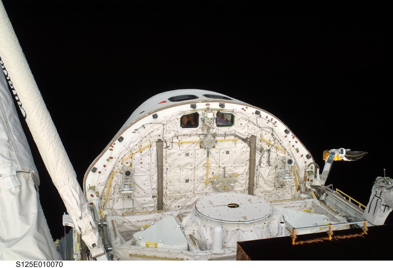 S125-E-010070 (18 May 2009) --- This scene, showing the cabin and forward cargo bay of the Earth-orbiting Space Shuttle Atlantis was photographed by one of the space walking astronauts during the mission?s fifth and final session of extravehicular activity (EVA) as work continues to refurbish and upgrade the Hubble Space Telescope. Astronaut Megan McArthur, STS-125 mission specialist, at the controls of the remote manipulator system (RMS), can be seen through an aft flight deck window.