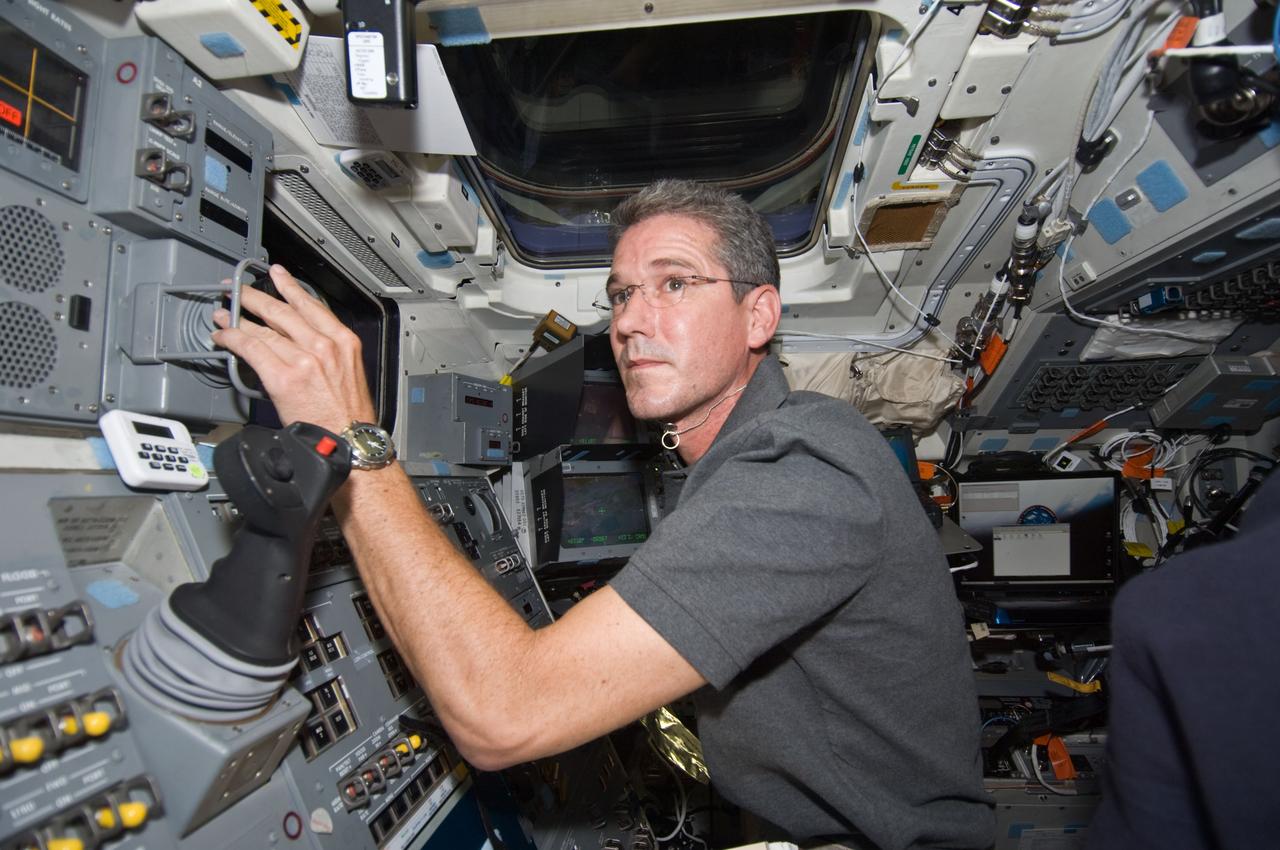S125-E-010161 (19 May 2009) --- Astronaut Michael Good, STS-125 mission specialist, works controls on the aft flight deck of the Earth-orbiting Atlantis on the day the space shuttle parts company with the Hubble Space Telescope for the final time.