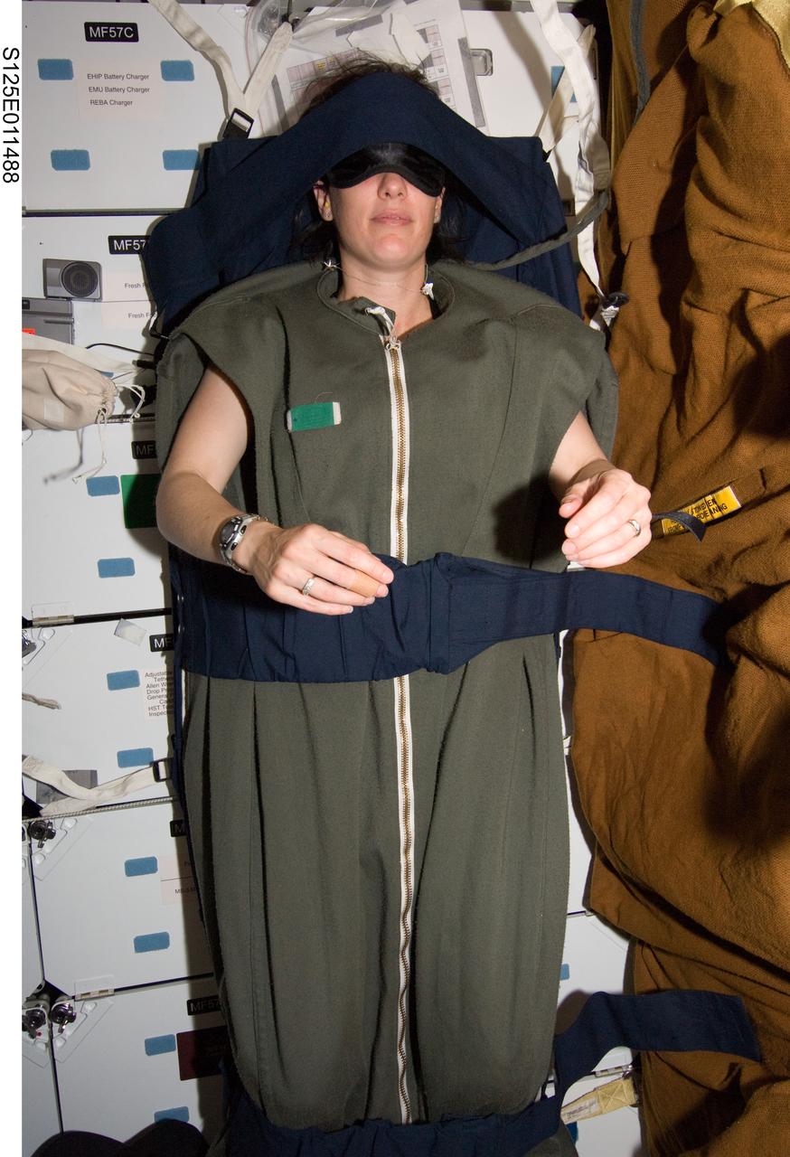 S125-E-011488 (18 May 2009) --- Astronaut Megan McArthur, STS-125 mission specialist, rests in her sleeping bag, which is attached to the lockers on the middeck of the Earth-orbiting Space Shuttle Atlantis at the end of flight day eight.