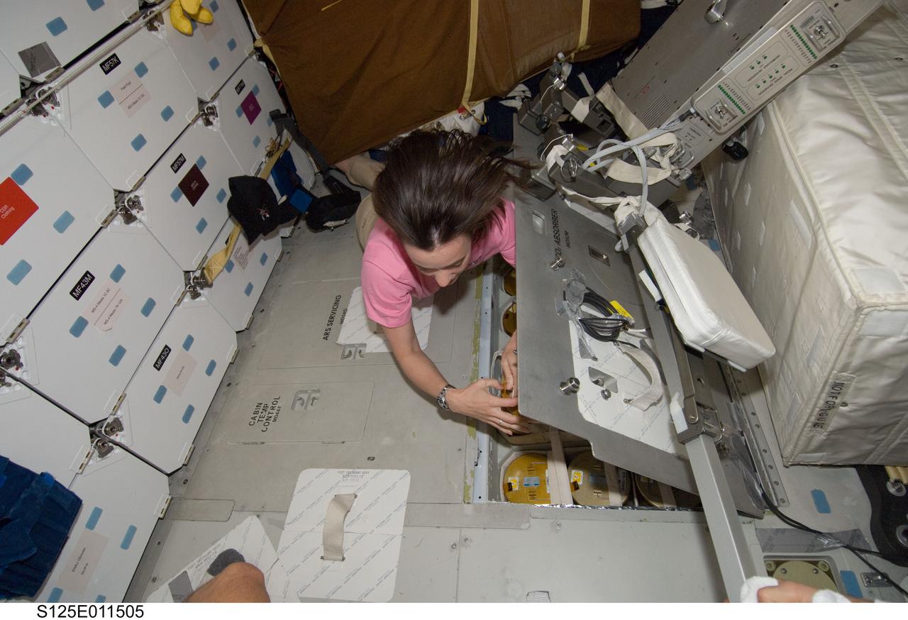 S125-E-011505 (19 May 2009) --- Astronaut Megan McArthur, STS-125 mission specialist, works with lithium hydroxide (LiOH) canisters from beneath Space Shuttle Atlantis' middeck during flight day nine activities.