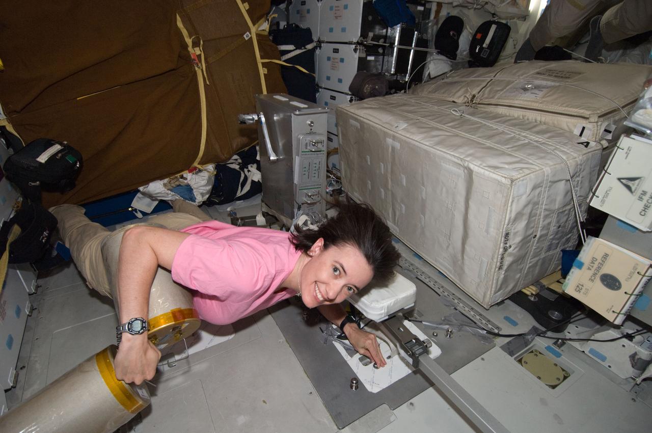 S125-E-011510 (19 May 2009) --- Astronaut Megan McArthur, STS-125 mission specialist, works with lithium hydroxide (LiOH) canisters from beneath Space Shuttle Atlantis' middeck during flight day nine activities.