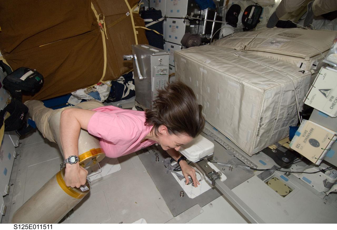 S125-E-011511 (19 May 2009) --- Astronaut Megan McArthur, STS-125 mission specialist, works with lithium hydroxide (LiOH) canisters from beneath Space Shuttle Atlantis' middeck during flight day nine activities.