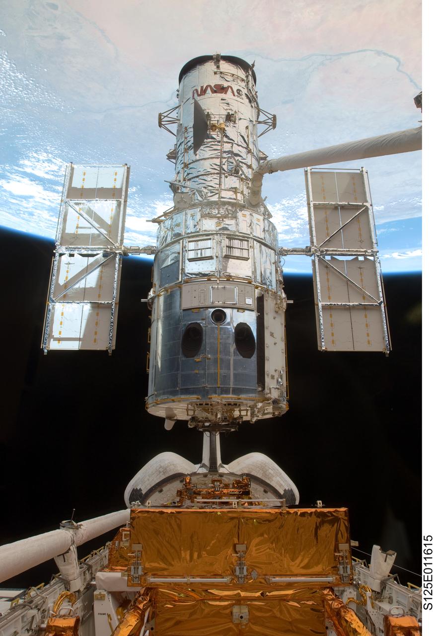S125-E-011615 (19 May 2009) --- The Space Shuttle Atlantis' remote manipulator system robotic arm lifts the Hubble Space Telescope from the cargo bay and is moments away from releasing the orbital observatory to start it on its way back home to observe the universe.