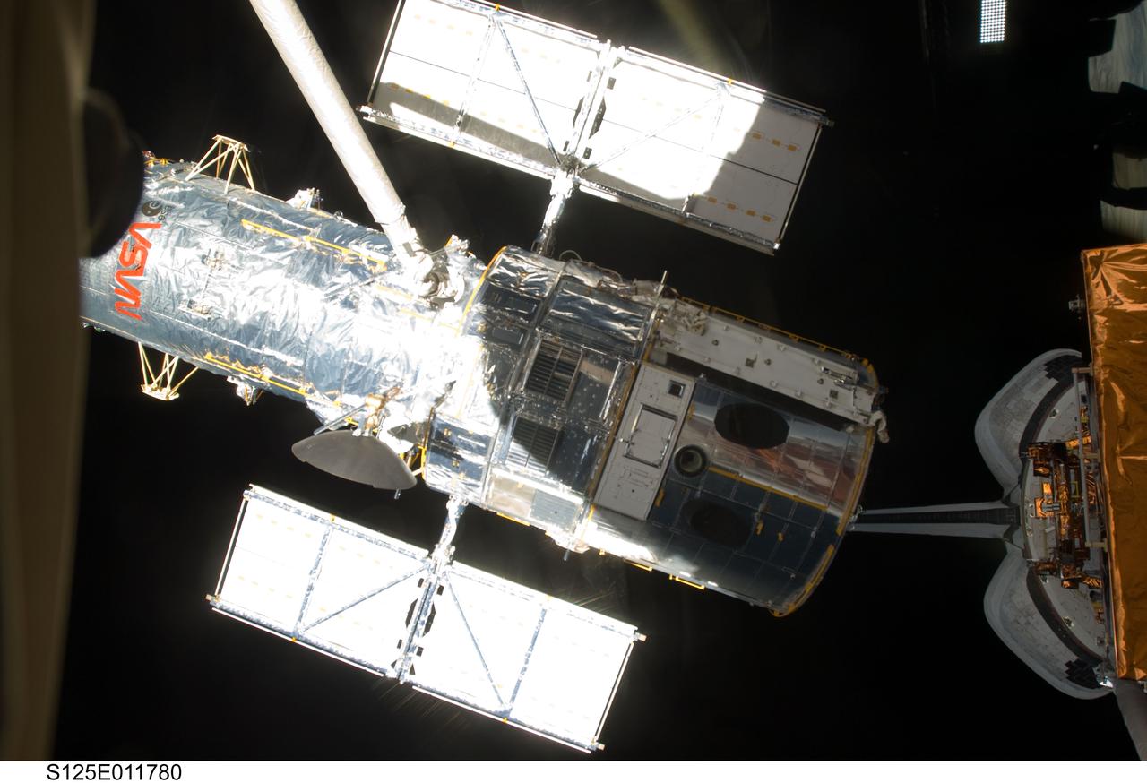 S125-E-011780 (19 May 2009) --- The Space Shuttle Atlantis? remote manipulator system arm lifts the Hubble Space Telescope from the cargo bay and is moments away from releasing the orbital observatory to start it on its way back home to observe the universe.