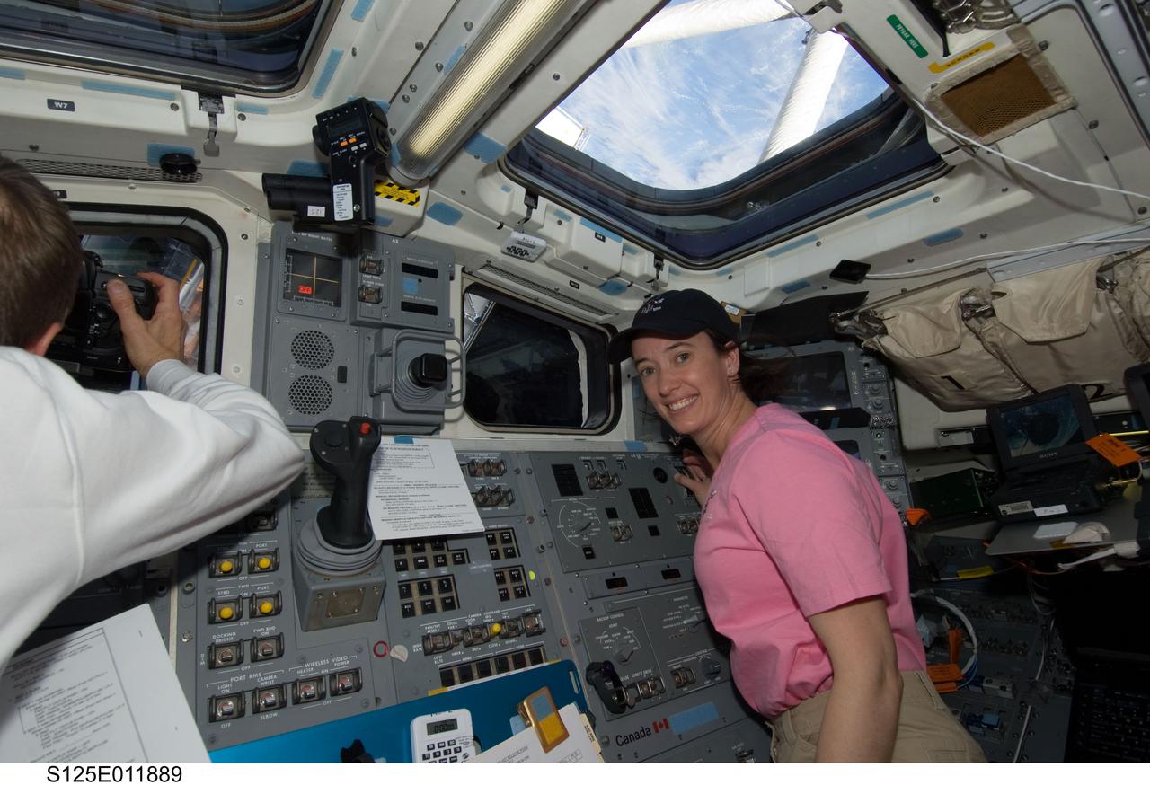 S125-E-011889 (19 May 2009) --- Astronaut Megan McArthur, STS-125 mission specialist, is pictured on the aft flight deck of the Earth-orbiting Space Shuttle Atlantis during flight day nine activities. Astronaut Gregory C. Johnson (partially out of frame), STS-125 pilot, is at left.