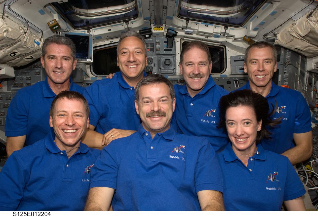 S125-E-012204 (20 May 2009) --- The crewmembers for the STS-125 mission pose for a photo following a news conference from the flight deck of the Earth-orbiting Space Shuttle Atlantis. Pictured on the front row are astronauts Scott Altman (center), commander; Gregory C. Johnson, pilot; and Megan McArthur, mission specialist. Pictured on the back row (left to right) are astronauts Michael Good, Mike Massimino, John Grunsfeld and Andrew Feustel, all mission specialists.