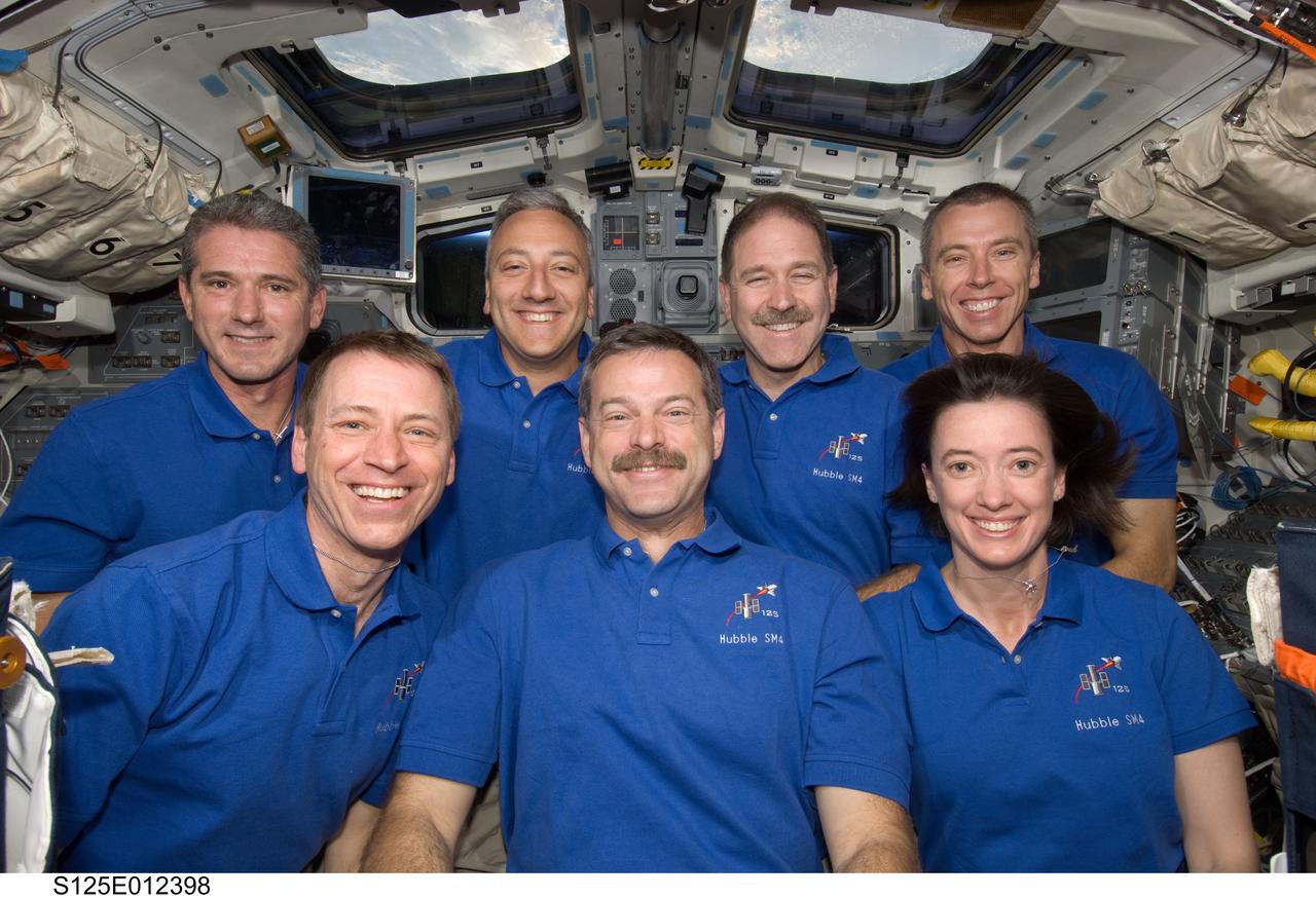 S125-E-012398 (20 May 2009) --- The crewmembers for the STS-125 mission pose for a photo following a news conference on the flight deck of the Earth-orbiting Space Shuttle Atlantis. Pictured on the front row are astronauts Scott Altman (center), commander; Gregory C. Johnson, pilot; and Megan McArthur, mission specialist. Pictured on the back row (left to right) are astronauts Michael Good, Mike Massimino, John Grunsfeld and Andrew Feustel, all mission specialists.