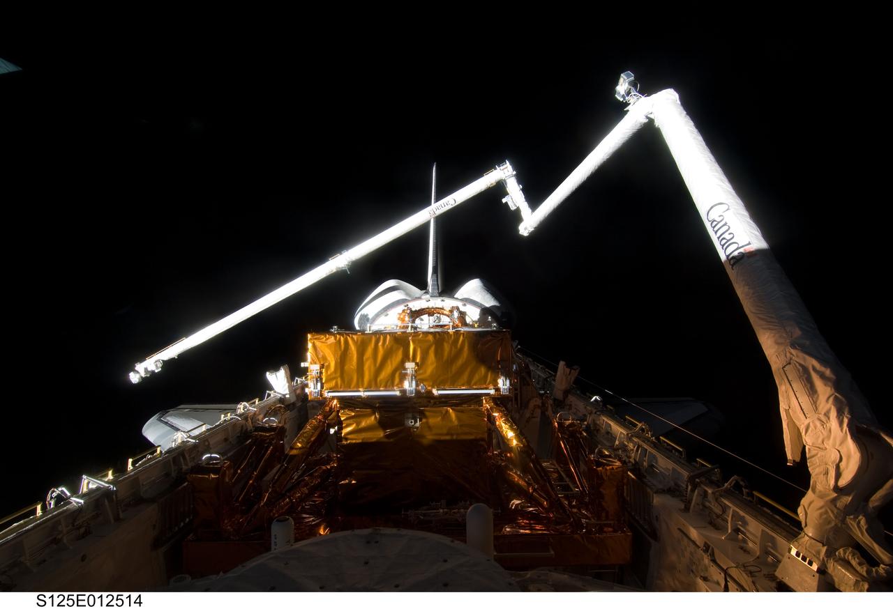 S125-E-012514 (19 May 2009) --- Space Shuttle Atlantis? payload bay, Canadian-built remote manipulator system (RMS) robotic arm, vertical stabilizer and orbital maneuvering system (OMS) pods are featured in this image photographed by an STS-125 crewmember on flight day nine.
