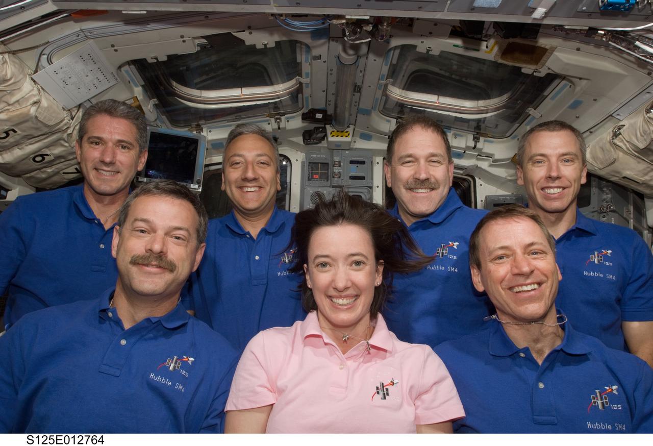 S125-E-012764 (20 May 2009) --- The crewmembers for the STS-125 mission pose for a photo on the flight deck of the Earth-orbiting Space Shuttle Atlantis. Pictured on the front row are astronauts Scott Altman (left), commander; Gregory C. Johnson, pilot; and Megan McArthur, mission specialist. Pictured on the back row (left to right) are astronauts Michael Good, Mike Massimino, John Grunsfeld and Andrew Feustel, all mission specialists.